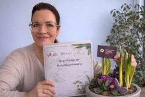 Rebekka Thor mit Zertifikat Marketingassisztenz und Blumengruß